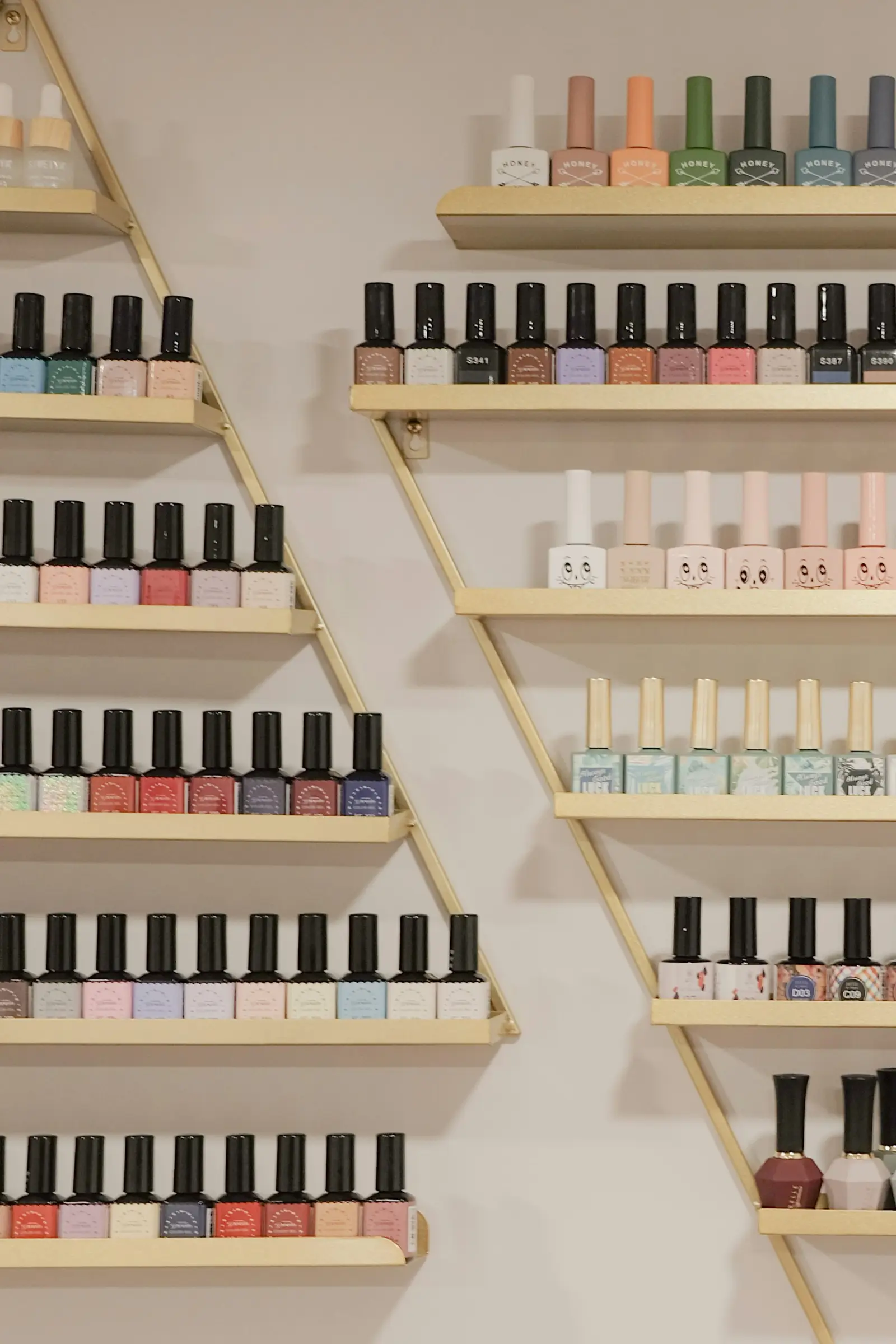 A wall of nail polish bottles on gold shelves